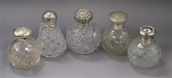 Five assorted Late Victorian and later silver topped cut glass scent bottles largest 13.4cm.